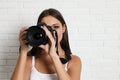 Professional photographer working near white wall in studio. Space for text Royalty Free Stock Photo