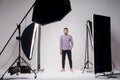 Professional photography studio showing behind the scenes lights. fashion handsome young man model at studio in the light flashes Royalty Free Stock Photo