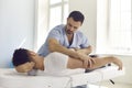 Chiropractor, osteopath, physiotherapist or manual therapist working with young man in modern clinic