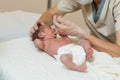 Professional physiotherapist performing a suction assessment in a newborn baby.