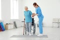 Professional physiotherapist working with elderly patient