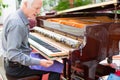 Professional piano technician removing keyboard for tuning repai