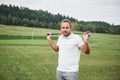 A professional player stands on the golf course and holds the metal stick behind his back Royalty Free Stock Photo