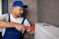 plumber handyman working in bathroom installing water closet pipe with wrench