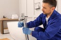 Professional plumber installing water tap in bathroom Royalty Free Stock Photo