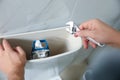 Professional plumber repairing toilet in bathroom Royalty Free Stock Photo