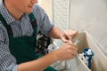 Professional plumber repairing toilet in bathroom Royalty Free Stock Photo