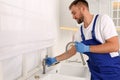 Professional plumber repairing water tap in kitchen Royalty Free Stock Photo