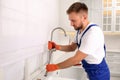 Professional plumber repairing water tap in kitchen Royalty Free Stock Photo