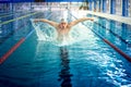 Professional polo player, male swimmer, performing the butterfly stroke technique at indoor pool, swimming practice Royalty Free Stock Photo