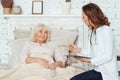 Professional positive female doctor examinig her patient at home