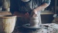 professional potter creating jar from brown clay in workplace using throwing-wheel. Traditional pottery, handmade Royalty Free Stock Photo