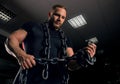 Professional powerlifter stands in the gym with iron chains