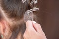 Professional process of hair extension for a woman with the help of artificial, in a beauty salon close up