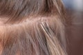 Professional process of hair extension for a woman with the help of artificial, in a beauty salon close up