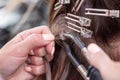 Professional process of hair extension for a woman with the help of artificial, in a beauty salon close up