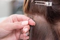 Professional process of hair extension for a woman with the help of artificial, in a beauty salon close up