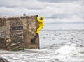 Professional in protective suit in sea reaching wall of bunker Royalty Free Stock Photo