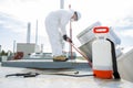 Professional in protective uniform, mask, gloves in the roof for cleaning