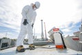 Professional in protective uniform, mask, gloves in the roof for cleaning