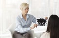 Professional Psychologist Testing Female Patient Showing Inkblot Picture In Office