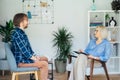 Professional psychotherapy. Female psychologist having session with male patient at mental health clinic, Taking Note Royalty Free Stock Photo