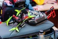 Professional quadcopter racing drone setup, remote control laying on a transport bag, AGH university campus drone race event