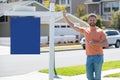 Professional realtor real estate agent with house for sale sign standing near residential property outside. Copy space. Royalty Free Stock Photo