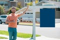 Professional realtor real estate agent with house for sale sign standing near residential property outside. Copy space. Royalty Free Stock Photo