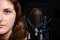 Professional record of the singer, close-up. Female vocalist on black background in recording Studio. Brunette girl for a silver