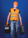 Professional repairman concept. Handyman, repairman on concentrated face carries heavy bags with professional equipment