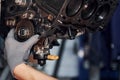 Professional repairman works with broken automobile engine