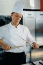 Professional restaurant kitchen, male chef sharpening a knife Royalty Free Stock Photo