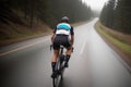 Professional road cyclist riding down wet and windy mountain road in forest, on aero road bike from carbon. AI