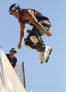 A professional roller skater performs a trick during an extreme sports outdoors show vertical