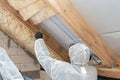 Professional roofer man installing thermal insulation layer with mineral rock wool