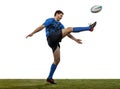 Professional rugby player wearinf blue sports uniform kicks ball isolated on white background. An incredible strain of Royalty Free Stock Photo