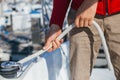 Man ties up nautical rope on winch on boat