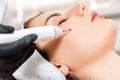 Professional salon procedures. Surgeon using a laser device for removing mole. Removal of birthmark from female face