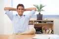 Professional satisfaction. Portrait of a smiling young businessman leaning back in his chair with his hands behind his Royalty Free Stock Photo