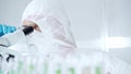 Professional scientist in protective gear is using microscope in a laboratory setting, close-up of researcher. Science Royalty Free Stock Photo