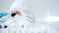 Professional scientist in protective gear is using microscope in a laboratory setting, close-up of researcher. Science Royalty Free Stock Photo