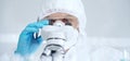 Professional scientist in protective gear is using microscope in a laboratory setting, close-up of researcher. Science Royalty Free Stock Photo