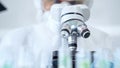 Professional scientist in protective gear is using microscope in a laboratory setting, close-up. Science and medicine Royalty Free Stock Photo