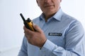 Professional security guard with portable radio set on background, closeup