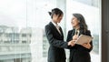 A professional senior Asian businesswoman is talking with a young colleague Royalty Free Stock Photo