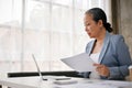 Professional senior businesswoman focuses on her business tasks and reports at her desk Royalty Free Stock Photo