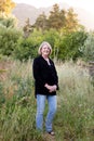 A professional senior woman standing outdoors in her garden.