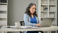 A professional Asian senior businesswoman working on her business work on her laptop Royalty Free Stock Photo