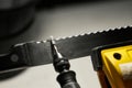 Professional serrated knife blade sharpening with a rotary tool. Macro Royalty Free Stock Photo